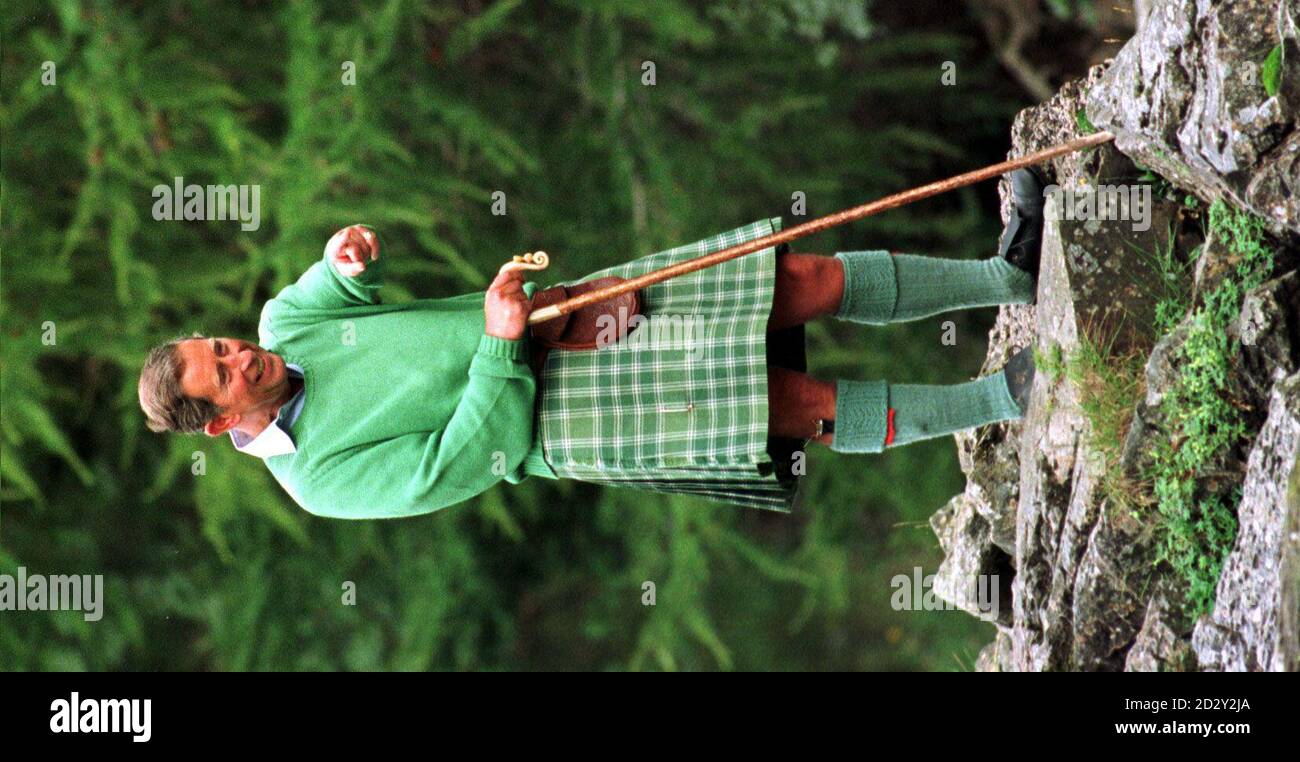 The Prince Of Wales cheerfully stands back and watches his sons Prince William and Prince Harry climb down beside the Falls of Muick on the Balmoral estate, Scotland where they are taking a summer break. Photograph by Fiona Hanson/PA. See PA Story ROYAL Charles. Stock Photo