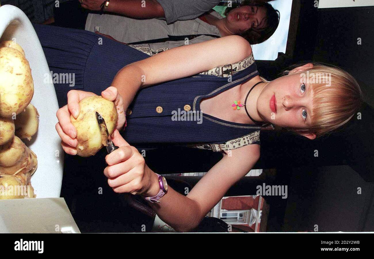 Demonstrates a left handed potato peeler in london hi-res stock