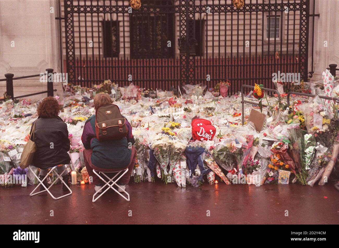Two mourners sit and contemplate outside the gates of London's Buckingham Palace today (Thursday) and pay their respects to Diana, Princess of Wales.  Photo by Ben Curtis/PA. Stock Photo