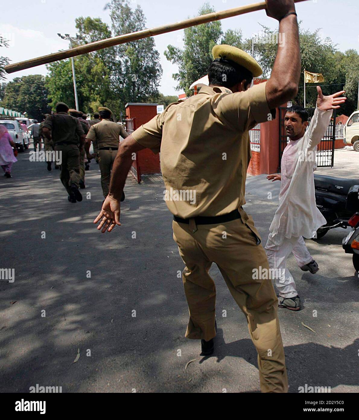 An Indian policeman wields a baton against a Pakistani refugee during a  protest in Jammu April 5, 2010. Dozens of Pakistani refugees, who  protesters said have been residing in Jammu since they