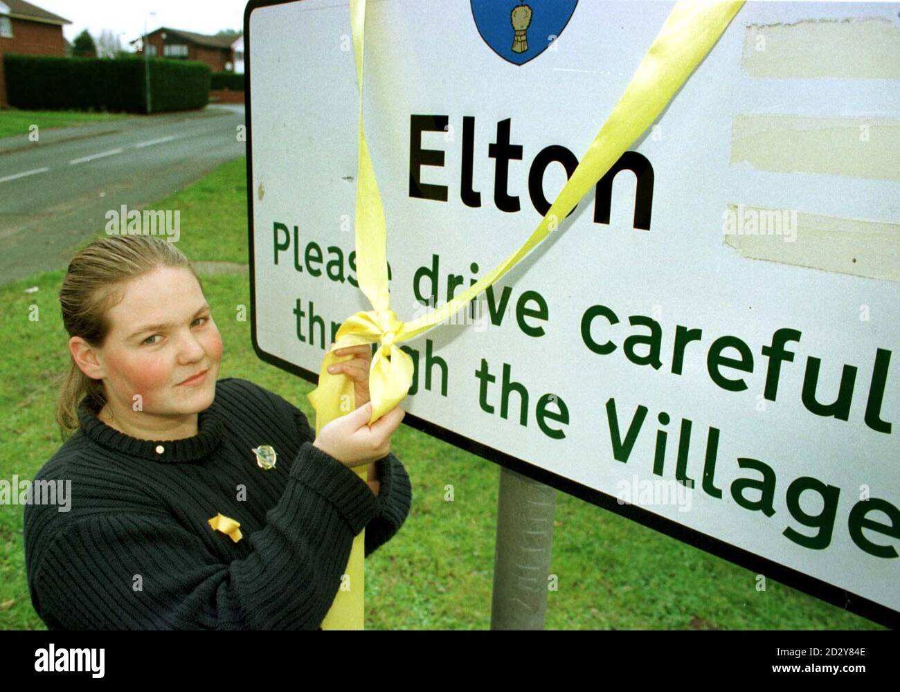 22-year-old Jacqui Pilling, a schoolfriend of convicted nanny  Louise Woodward, ties a yellow ribbon around the village sign in Elton, Cheshire, today (Sat) as Louise begins her life sentence in the US after being found guilty for the murder of Matthew Eappen. Photo By Bob Collier. See PA Story COURTS Nanny. Stock Photo