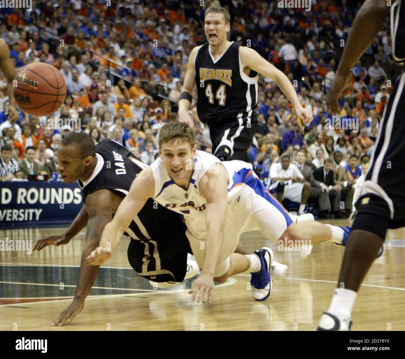University of Florida Gators guard Lee Humphrey (bottom) and  Wisconsin-Milwaukee Panthers guard Boo Davis (L) collide while going for a  loose ball as forward Adrian Tigert (44) watches, during the second round
