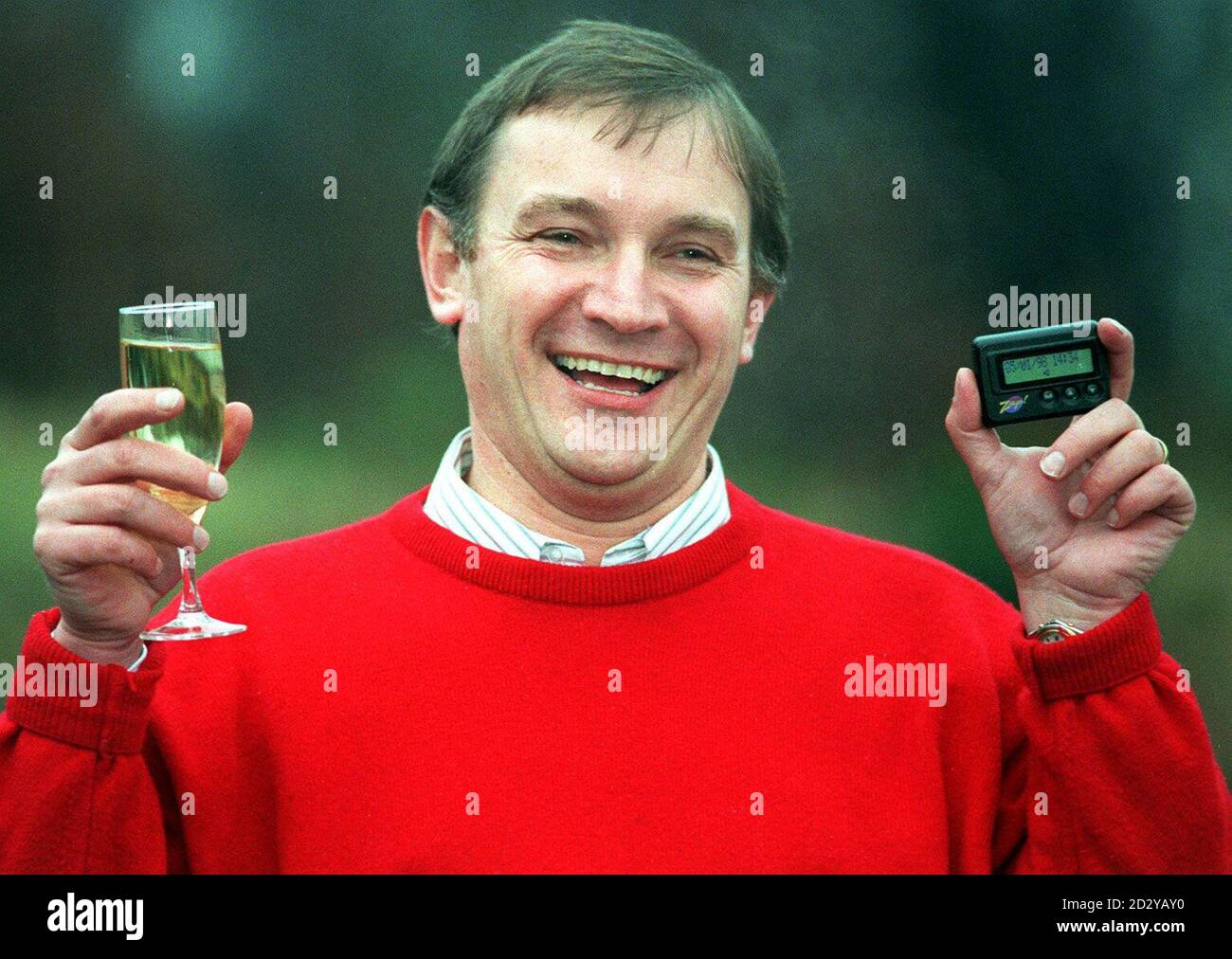 Lottery Winner Geoff Bogg (correct) from Retford in North Nottinghamshire, celebrates his  3 million win today (Monday) with champagne and holds up the Pager on which he received the good news. See PA story LOTTERY Winner. PA picture. Stock Photo