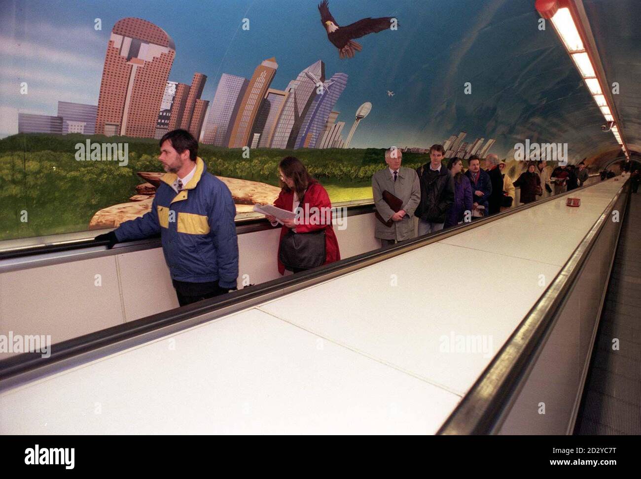 Commuters travel past London's largest landscape painting along the wall of the Trav-o-lator (moving walkway) at Bank Underground Station in London after it was unveiled earlier today (Monday).  The 282 foot,  1.5 million mural, which is American Airlines' latest advertising campaign, depicts a 5,000 mile East to West trip across the USA.  Photo by Neil Munns/PA Stock Photo