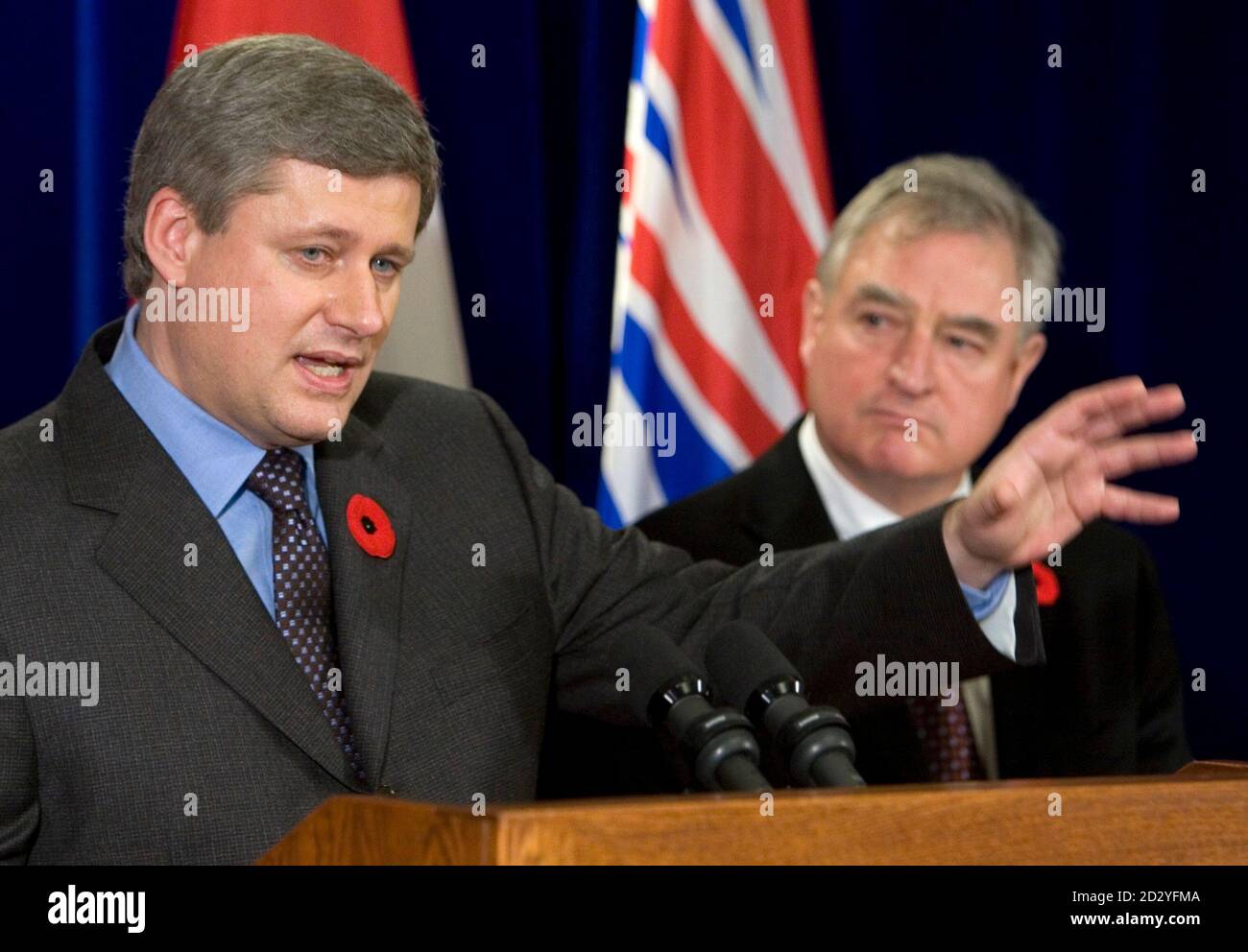 Canadian Prime Minister Stephen Harper (L) gestures as Trade Minister David Emerson looks on during a news conference in Vancouver, British Columbia November 7, 2007.       REUTERS/Andy Clark        (CANADA) Stock Photo