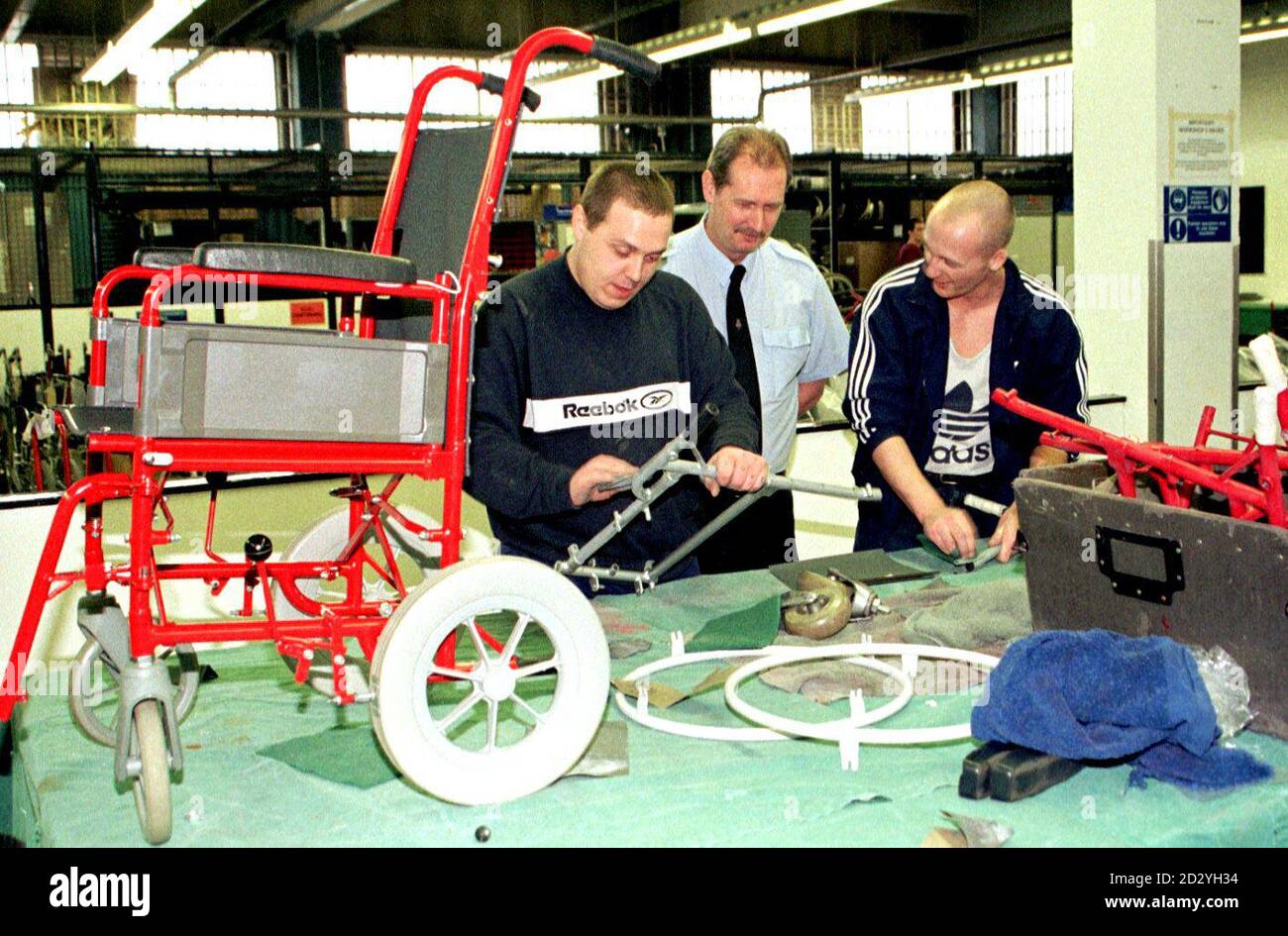 A prison officer (centre) supervises inmates in the wheelchair