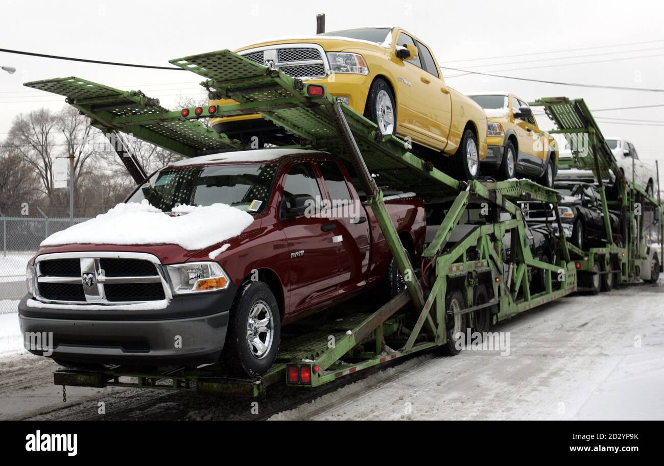A car hauler transports new Dodge Ram pickup trucks from a lot next to