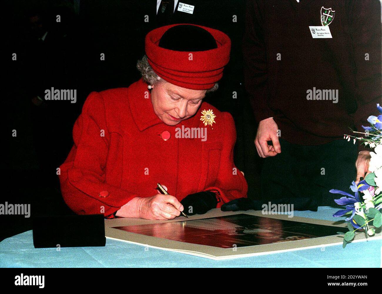 PA NEWS 20/3/98 HER MAJESTY THE QUEEN SIGNS A PHOTGRAPH OF HERSELF DURING A VISIT TO KESWICK SCHOOL IN CUMBRIA. Stock Photo