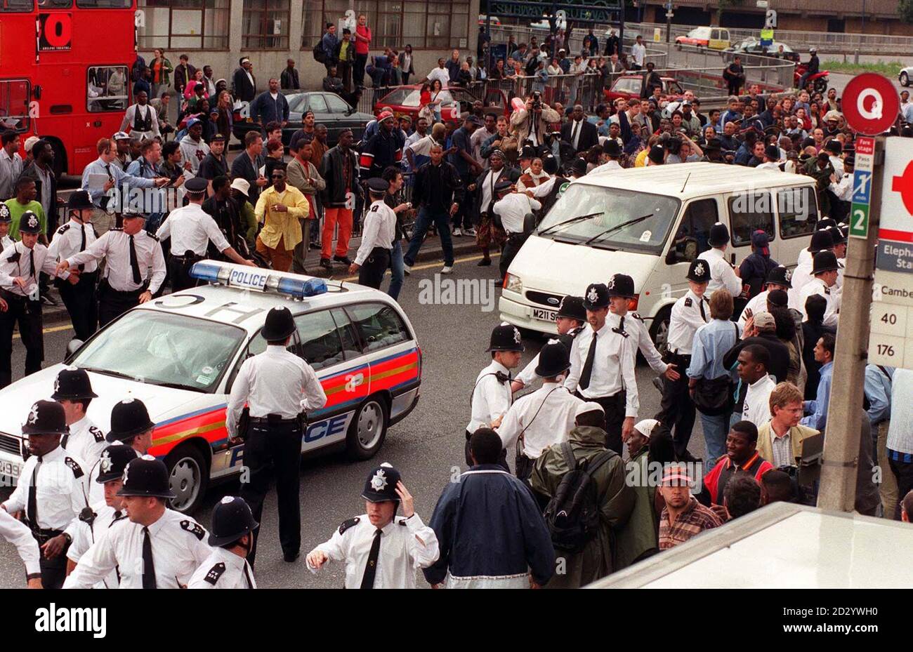A police car leads a van transporting the five murder suspects away from the crowds of angry demonstrators after the two days of questioning in the Stephen Lawrence Murder Inquiry came to an end. Stock Photo