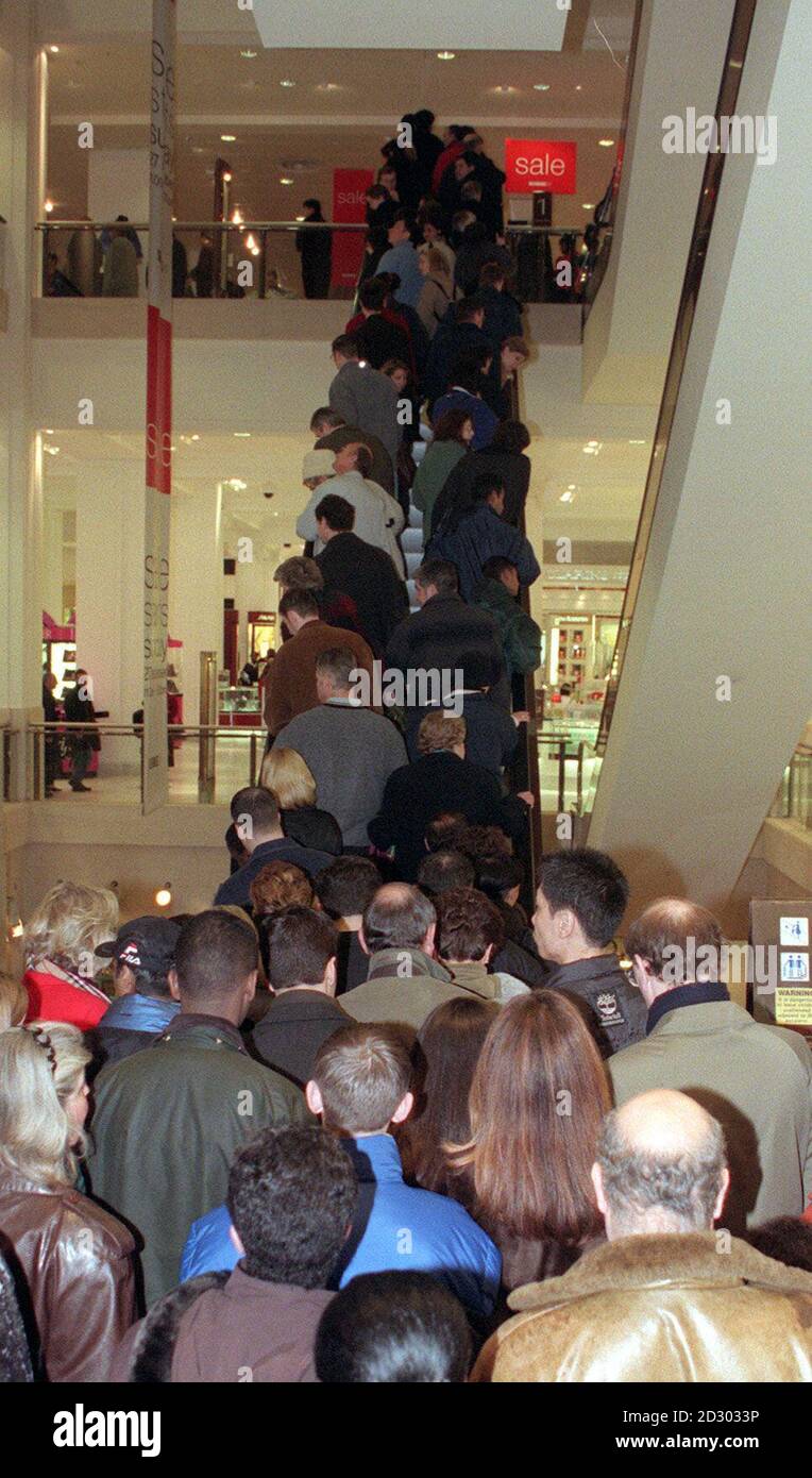 Shoppers queue to take an escalator to the first floor of Selfridges department store in central London, during its post-Christmas sale. Stock Photo