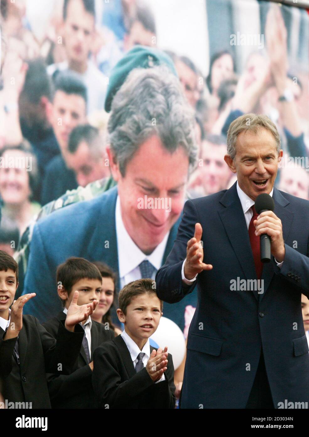 Britain's former prime minister Tony Blair (R) speaks in front of nine  Kosovo Albanian boys named after him on stage in Pristina July 9, 2010.  Blair is on a two-day visit to