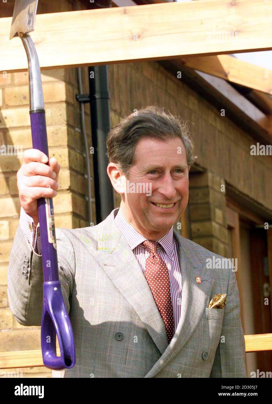 The Prince of Wales holds aloft a spade after planting a holly tree during a visit to the Macmillan cancer care centre in Guildford today (Wednesday). PA Photos (Reuter rota pic) Stock Photo