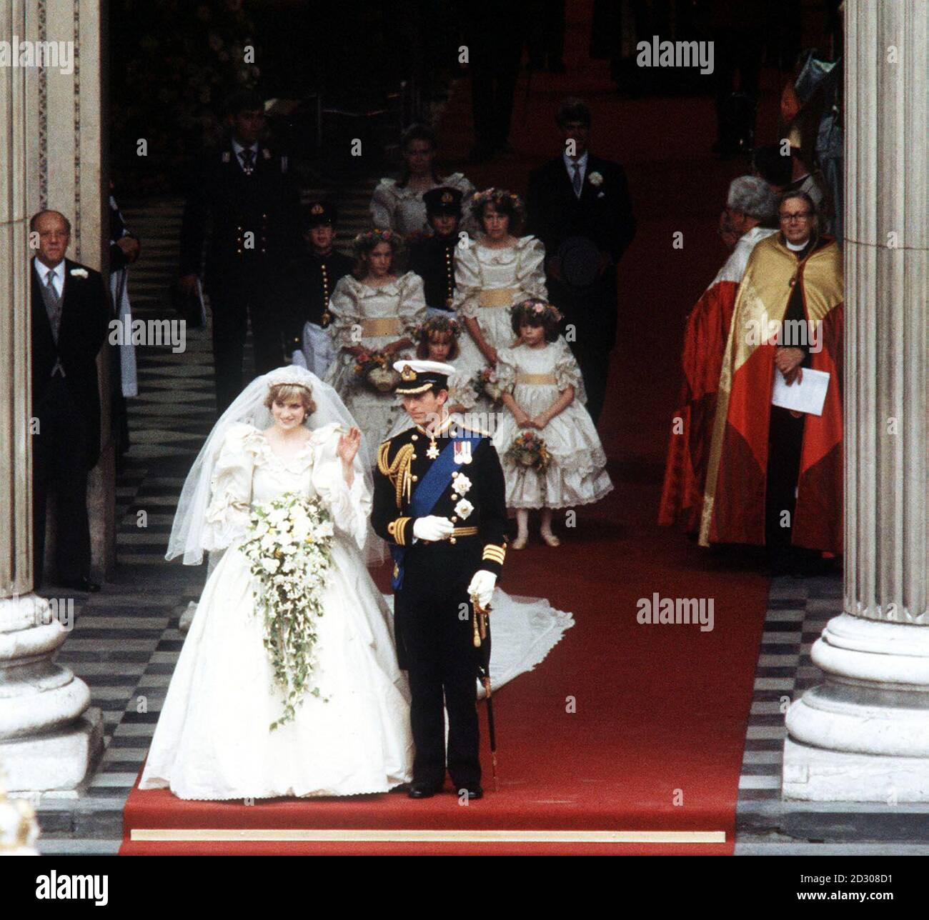 The Princess of Wales, formerly Lady Diana Spencer, waves to the crowds as she leaves St. Paul's Cathedral in London with her husband, the Prince of Wales after their wedding ceremony. The Princess' dress was designed by Elizabeth and David Emanuel. * has a 25ft long detachable train. Her veil of ivory silk tulle, spangled with thousands of tiny hand-embroidered mother-of-pearl sequins, is held in place by the Spencer Family diamond tiara. Stock Photo