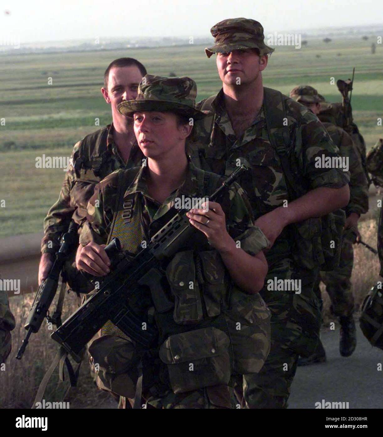A young woman soldier marches with troops on the outskirts of Pristina, the capital of Kosovo. 24/12/00: The Army has moved a step closer towards allowing women to serve in frontline combat roles. * Field trials to assess whether women could perform in combat alongside men found that the two sexes interacted well in almost all situations, according to a report in The Observer. The tests, conducted on Salisbury Plain during the autumn, are part of a three-phase programme which will determine whether the barrier to women serving on the frontline should be removed. A report will be presented Stock Photo