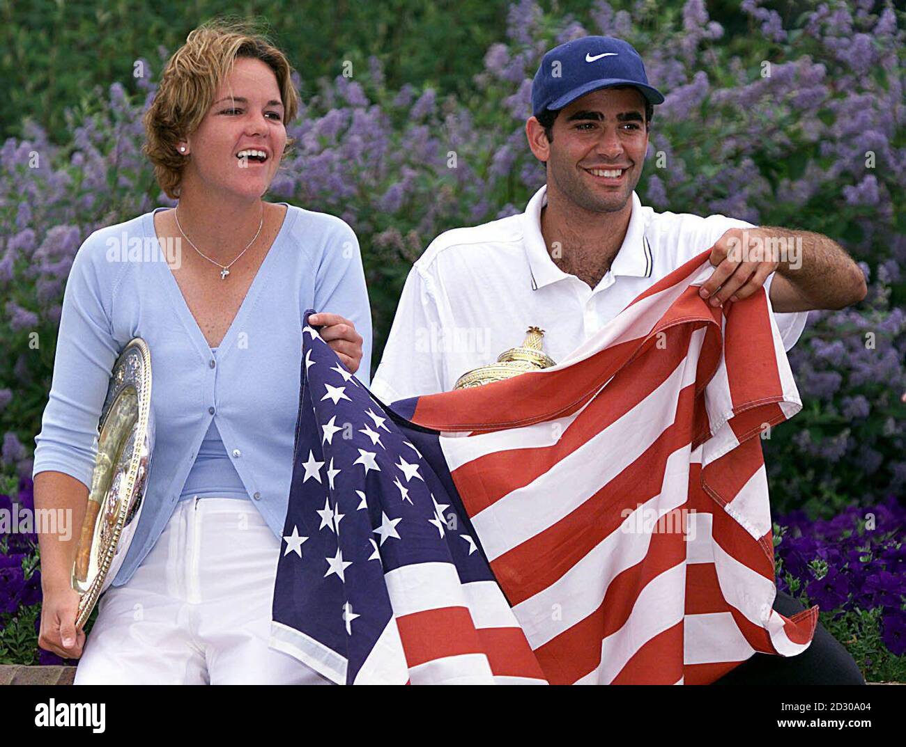 No Commercial Use : Wimbledon single winners Lindsay Davenport and Pete Sampras struggle with the American flag after wind engulfed them during a photo-call at Wimbledon. Sampras defeated Agassi 6-3 6-4 7-5  and Davenport defeated Graf 6-4 7-5. Stock Photo