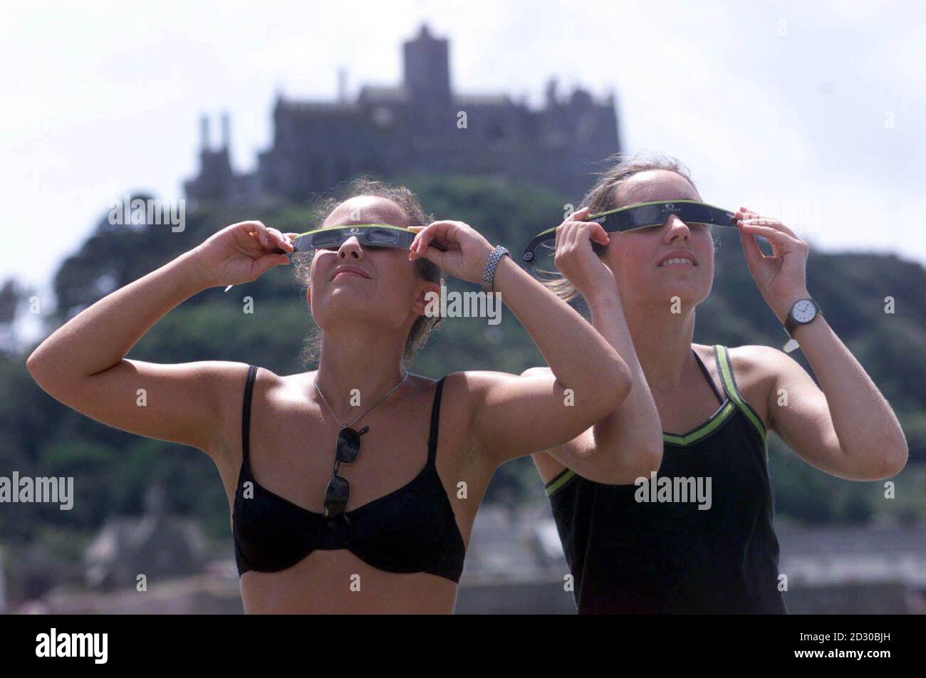 Ana Diego (left) and Gemma Mudu practice looking at the Sun at St Michael's Mount in Cornwall, a day before before the total eclipse of the Sun. Stock Photo