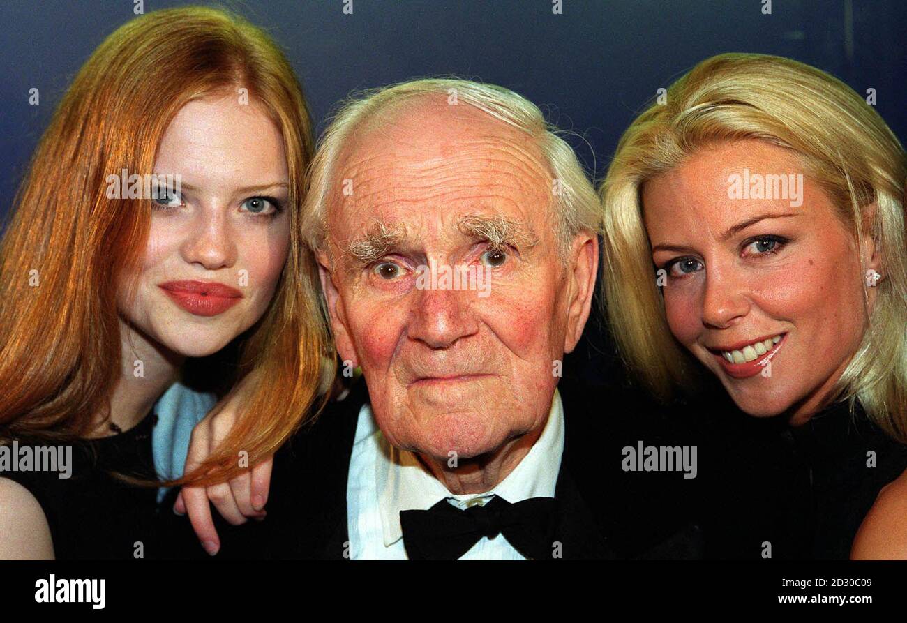Actor Desmond Llewelyn, who plays the World famous 'Q' in the James Bond films with 'Bond Beauties' Kirsty (l) and Maxine after opening the Licence to Thrill ride, which offers a Bond experience, at the Trocadero Centre in London's Piccadilly. Stock Photo