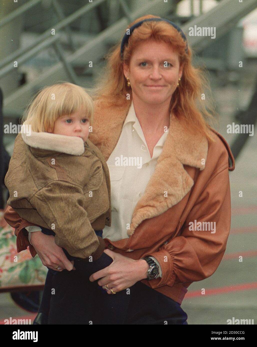 The Duchess of York carries her daughter, Princess Beatrice, to a
