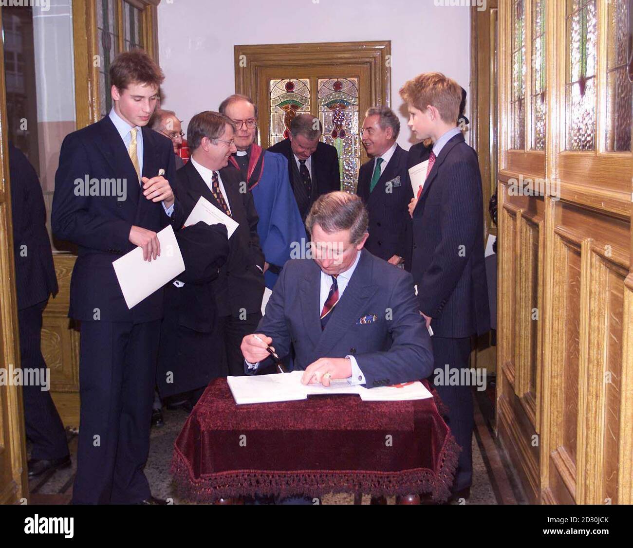 The Prince of Wales signs the visitors book at the Tabernacl Church in Hayes, Cardiff, where he attended a  millennium service, Sunday 2nd January 2000, accompanied by the princes William (left) and Harry (right). NPA/D Mirror Rota photo by Kent Gavin.  Stock Photo