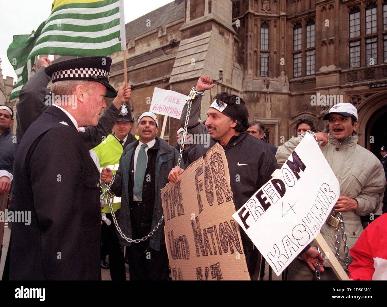 A group of around 15 Kashmiri protesters who chained themselves to the railings outside the House of Commons, in order to highlight the territory's treatment under Indian rule. Police cut the protesters free and moved them away from the  area.  Stock Photo
