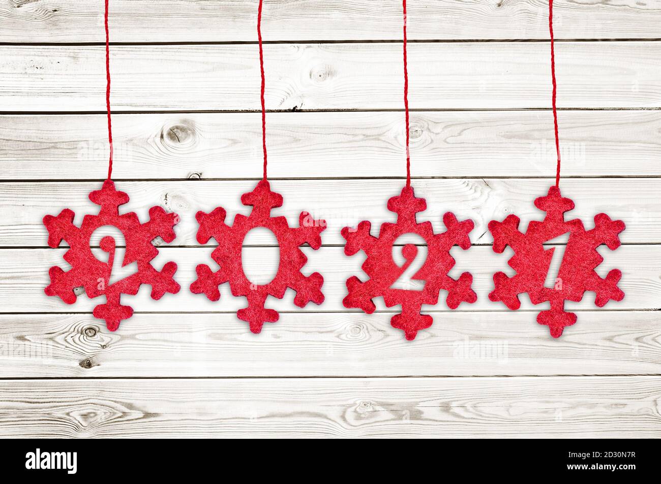 2021 cut in red fabric christmas ornaments hanging on white planks background Stock Photo