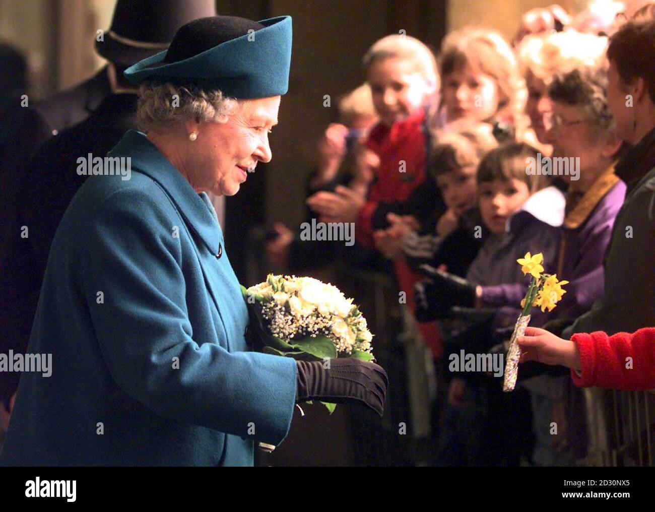 The Queen receives flowers from a member of the public at the Imperial