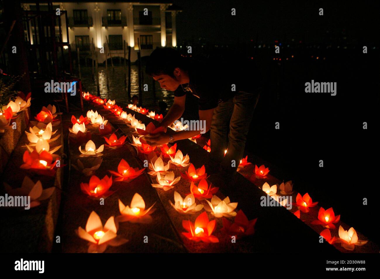 A man lights candles during Earth Hour by the West lake in Hanoi March 27,  2010. Earth Hour, when everyone around the world is asked to turn off  lights for an hour