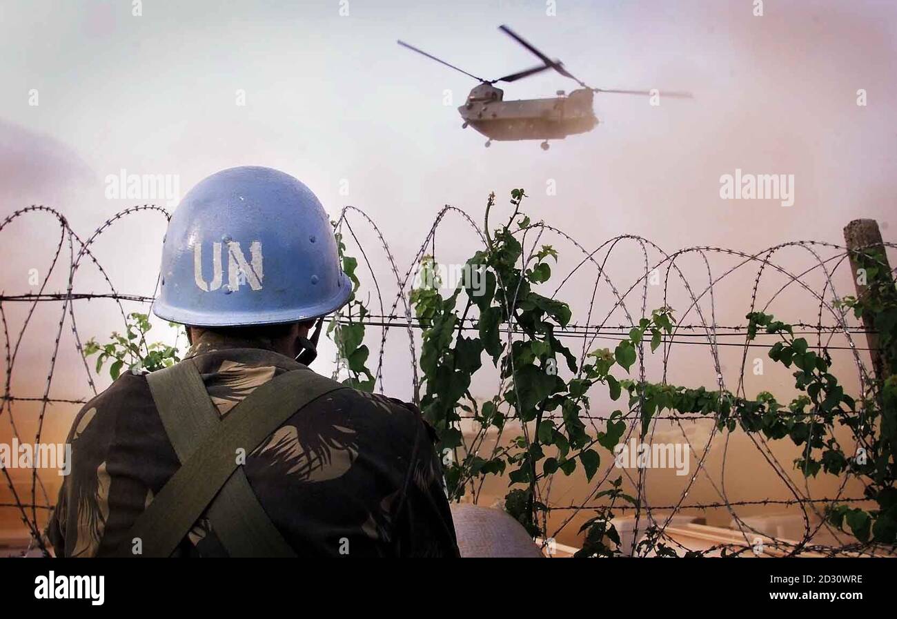 An Indian UN soldier watches as an RAF Chinook returns empty from the helipad at the United Nations Headquarters to the International airport at Freetwon Sierra Leone Tuesday May 9, 200. Some 200 soldiers from the 1st Battalion the Parachute Regiment have arrived in the country to help with the evacuation of British citizens.  See PA story DEFENCE Sierra Leone.  PA photo: Peter Macdiarmid/The Independent/MOD pool. Stock Photo