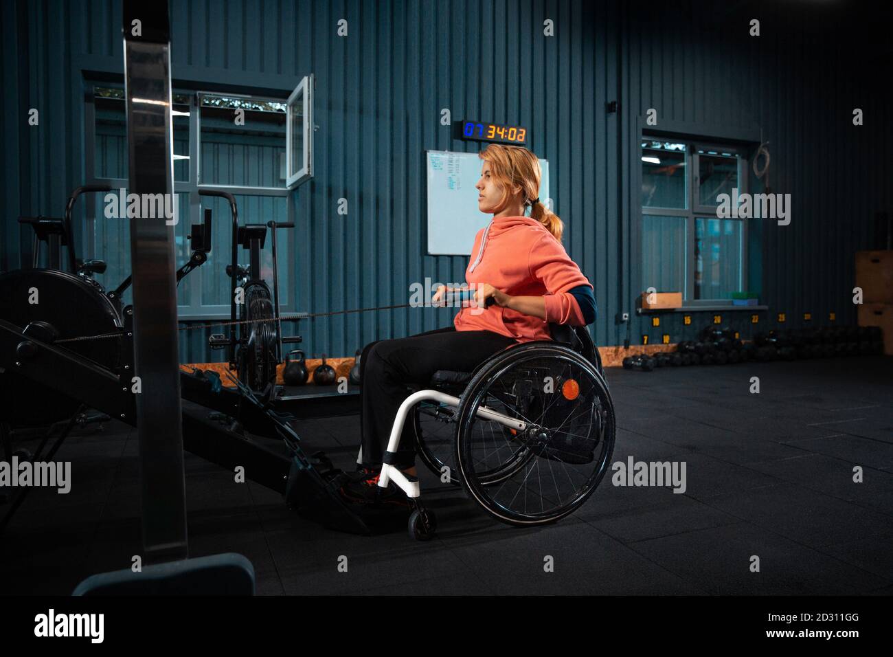 Weights. Disabled woman training in the gym of rehabilitation center, practicing. Active woman with handicap. Concept of healthy lifestyle, motivation, concentration, inclusion and diversity. Stock Photo