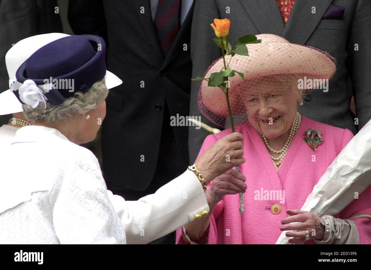 The Queen, front left, and the Queen Mother, who is given a rose while leaving church on the Sandringham Estate, Norfolk. Stock Photo