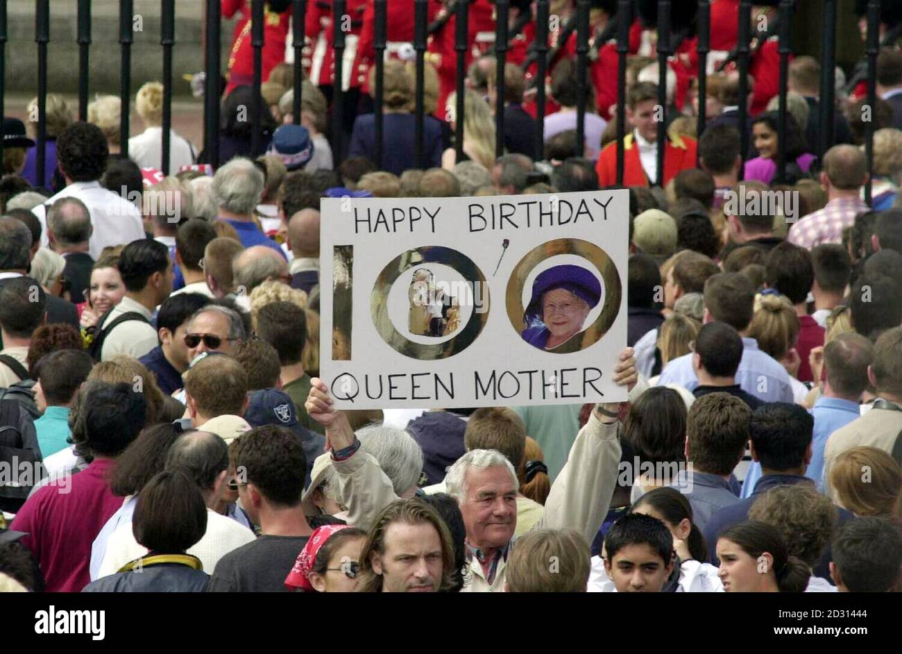 Crowds gather outside Buckingham Palace in London, waiting for the Queen Mother to appear on the Balcony during her 100th Birthday celebrations. Stock Photo