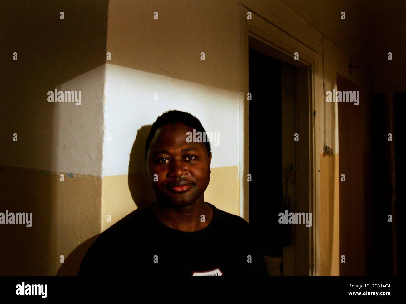 Ayouba Kenneh, a Liberian refugee living in Israel for the past 10 years, stands in his apartment in Tel Aviv March 13, 2007. A group of Liberian refugees given sanctuary in Israel five years ago now face deportation and fear their lives will be in danger if they are repatriated. The United Nations ruled last year that it was safe for refugees to return home, but many, traumatised by the deaths of family members there, are still fearful. Israel granted temporary protection in 2002 to a group of Liberians, who now number 86, including 16 children born in Israel. Their protected status expires o Stock Photo