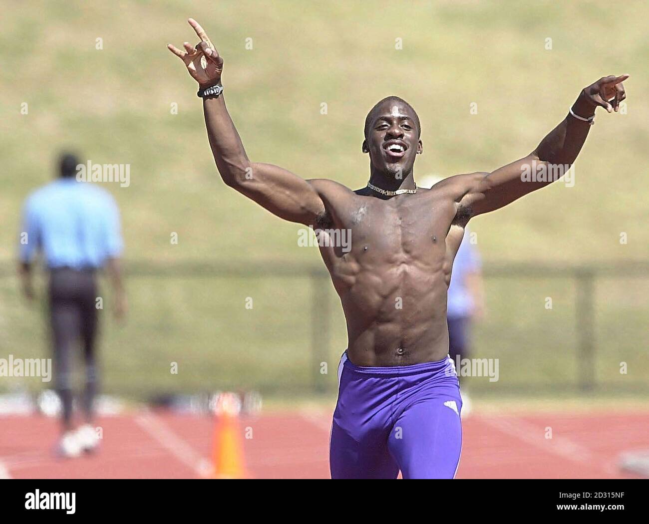 Dwain Chambers celebrates victory over Linford Christie (walking  back) after Christie pulled up in a fun race, at the Great Britain Athletics Training Camp on the Gold Coast of Australia. Stock Photo