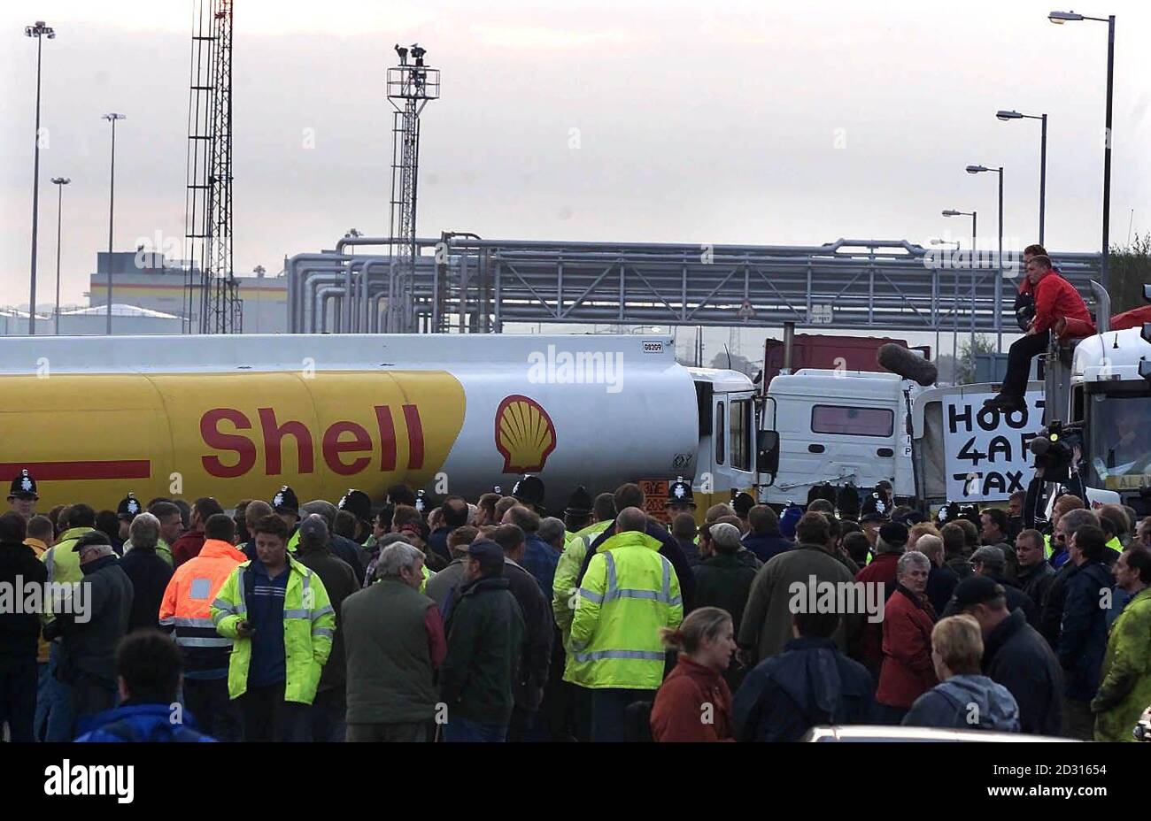 Protesters look on as 'essential fuel' loads are driven from the Shell Oil refinery in Stanlow Cheshire. Eight tankers left the Stanlow oil refinery at the scene of the first fuel price demonstrations. * 24/01/2001: Tanker drivers are to be balloted for strikes in a dispute over pay, threatening fresh shortages of fuel supplies, union officials warned. Hundreds of workers who drive Shell tankers will begin voting tomorrow after they rejected a proposed two-year wage deal. The men, who are employed by P&O Trans European, drive about one sixth of the country's entire fuel tanker fleet, accordin Stock Photo