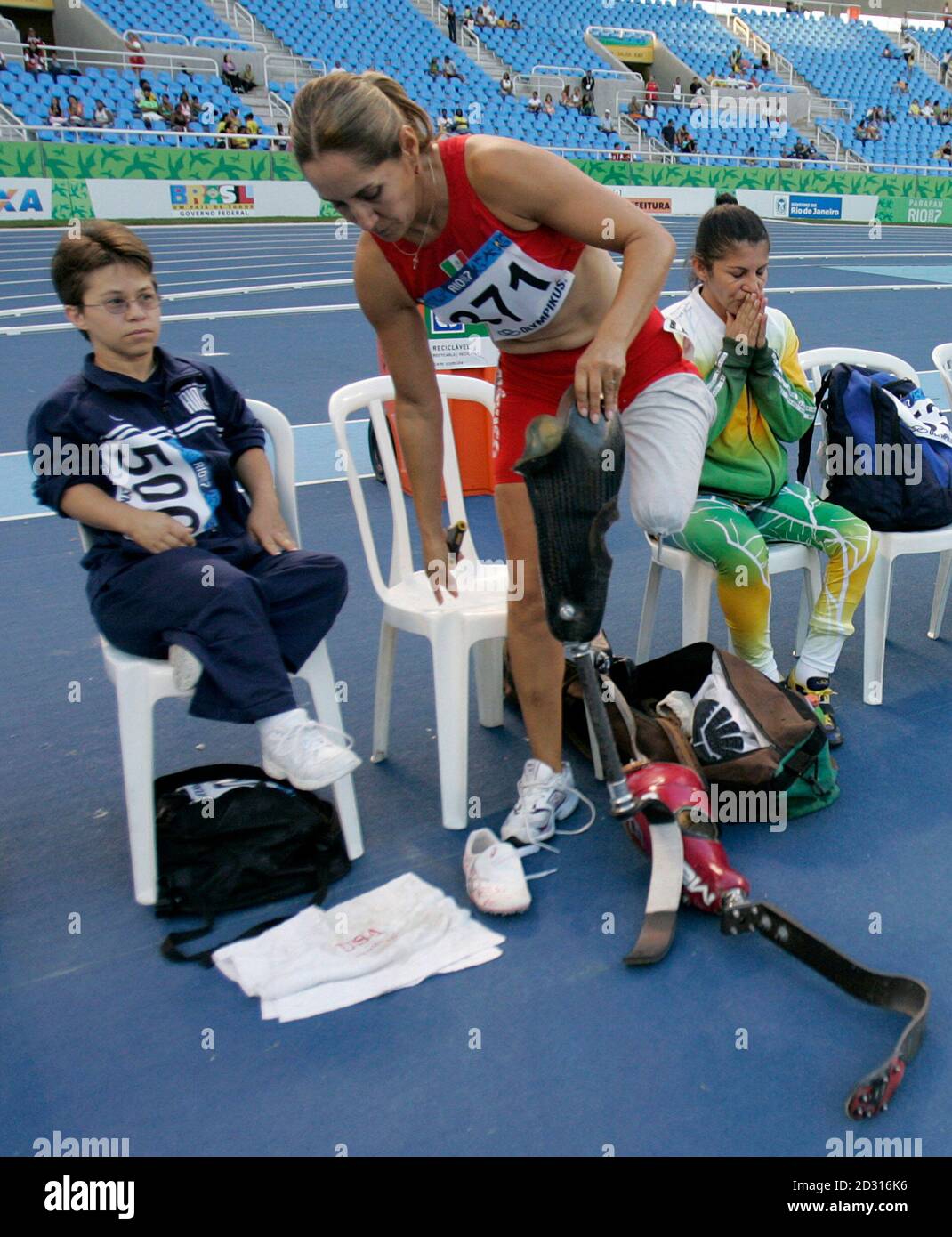 Mexico's Cor Bustamante (C) changes her prosthetics after the women's 100m T46 during the Parapan American Games in Rio de Janeiro August 15, 2007.  REUTERS/Bruno Domingos (BRAZIL) Stock Photo
