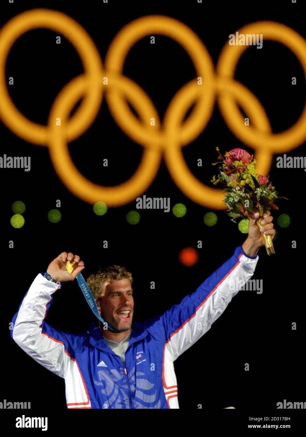 Great Britain's Gold medallist Iain Percy celebrates his Olympic Games success in front of the Harbour Bridge, in Sydney, Australia. Percy won his Gold Medal in the Men's Finn Sailing Class. Stock Photo