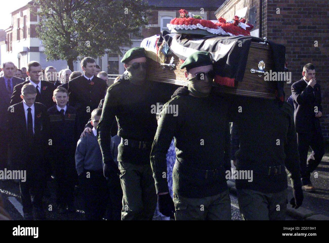 Four masked men in paramilitary-style uniforms  accompanied the coffin of leading loyalist Tommy English, murdered during bitter feuding in north Belfast.   *Several hundred mourners, including Belfast Deputy Mayor Frank McCoubrey of the Ulster Democratic Party, which is linked the Ulster Defence Association, gathered outside Mr English's mother's home in Mervue Street for the private funeral service. Stock Photo