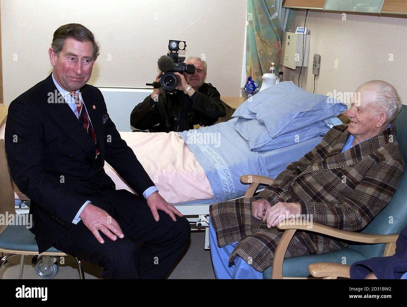 The Prince of Wales (left) talks to patient Victor Humphreys as he makes his way through the North West Wales Cancer Treatmen Centre at Glan Clwyd hospital in Boelwyddan, Rhyl, North Wales, during a visit to the region. Stock Photo