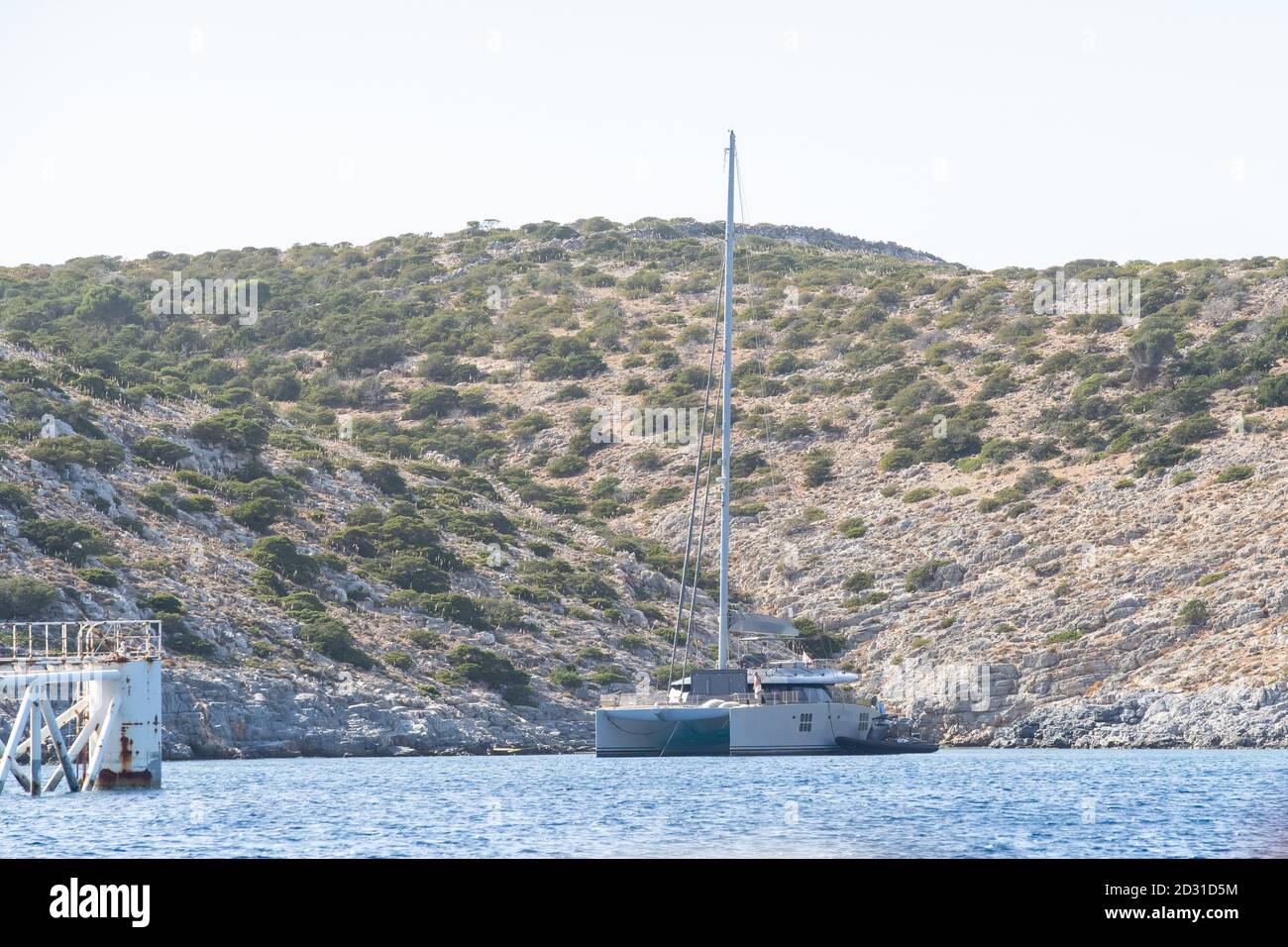 A metal catamaran anchored right beside the solarwind power production on a floatable construction at Iraklia,Cyclades,Greece Stock Photo