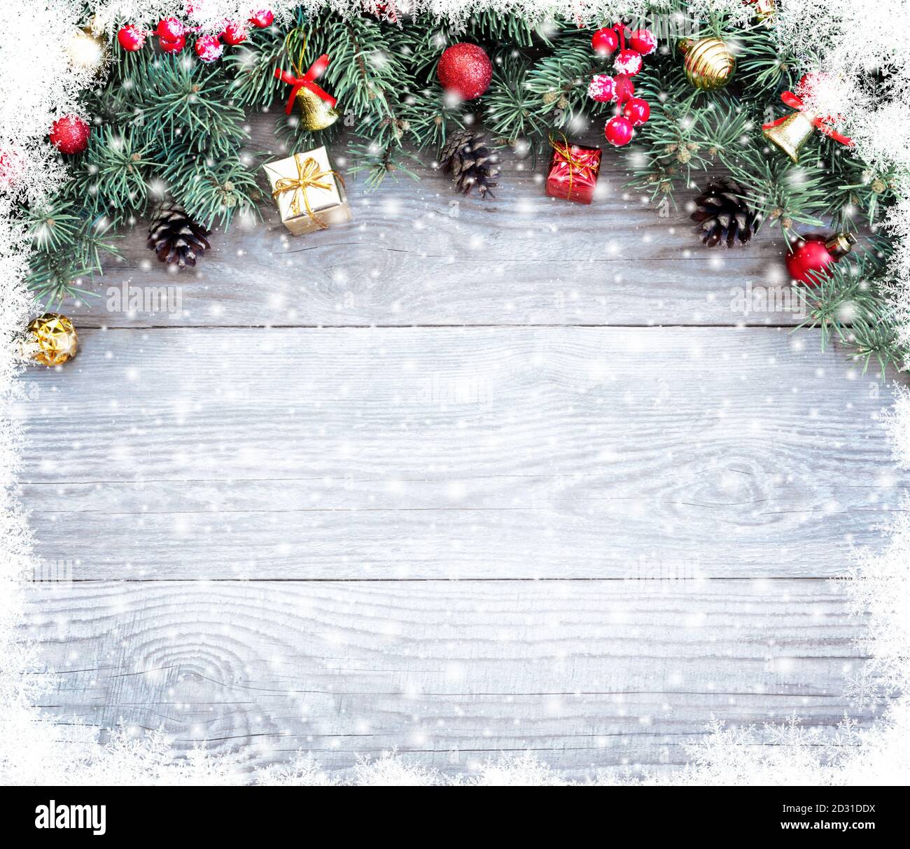 Christmas fir tree branches with toys on old wooden table with bokeh light. Beautiful Christmas background. Stock Photo