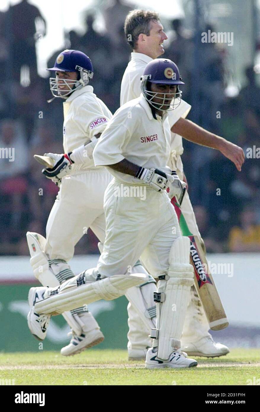 Sri Lankan batsmen Marvan Atapattu (left) and Chaminda Vaas cross for  another run past England's Andrew Caddick, during the second day of the  first Test at Galle International Cricket Stadium, Galle, Sri
