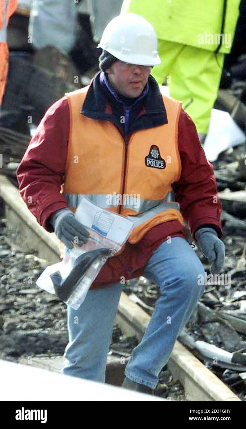 A police officer carries away a shoe from the wreckage at Gt Heck, nr Selby, Yorkshire, where work is continuing following the railway crash in which 13 people are thought to have died.    * However, police have warned that more bodies may be recovered as the process of lifting the wrecked carriage begins. A road has been constructed to allow access for a giant crane, but officials say that the lifting process will only start once the recovery of passengers' belongings have been completed. Stock Photo