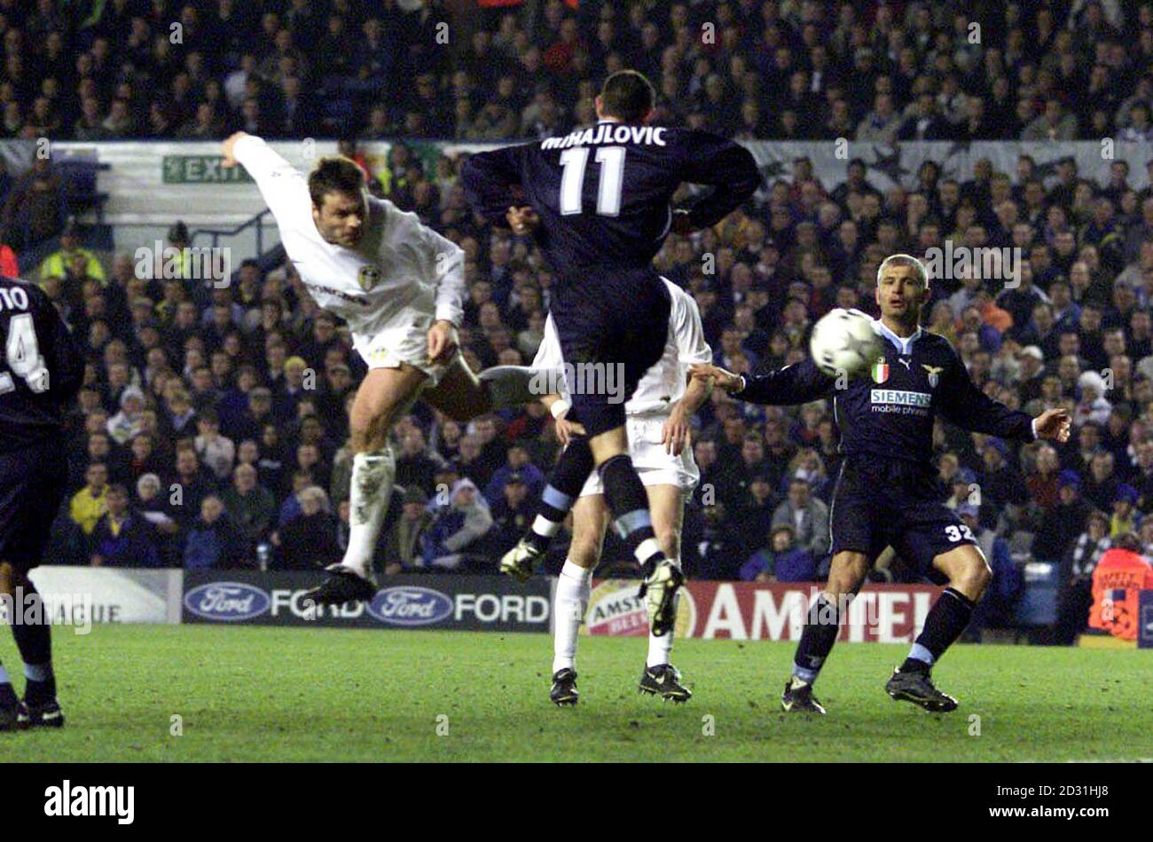 Leeds United's Mark Viduka (L) powers the ball past the Lazio defence to score, during their Champions League football match at Elland Road, in Leeds. Stock Photo