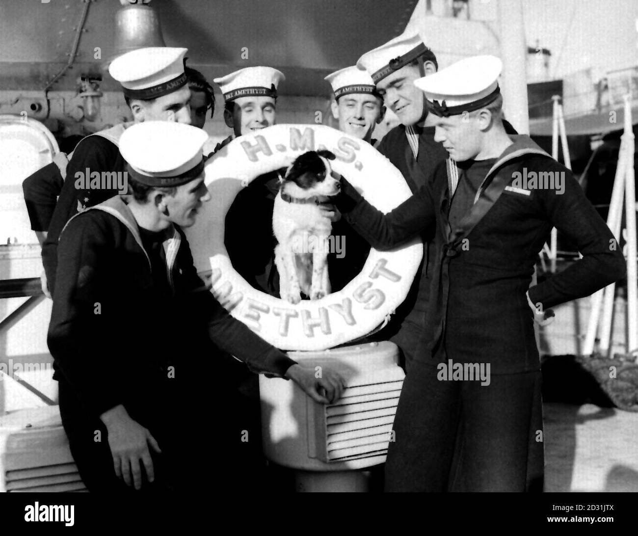 HMS AMETHYST 1952: The frigate that made a spectacular dash down the Yangste River under Chinese guns returned to Devonport after 2 years in the Far East. Here are some of the crew with the ship's dog, Joe, who was 'recruited' in Malta. He wears the Korea ribbons of the UN and the British Empire. Stock Photo