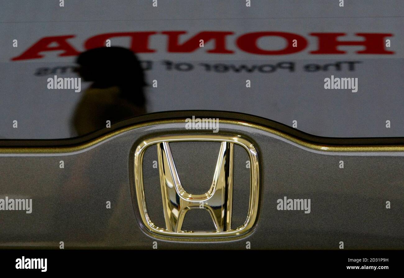 A woman and the logo of Honda Motor Co are reflected on a Honda 