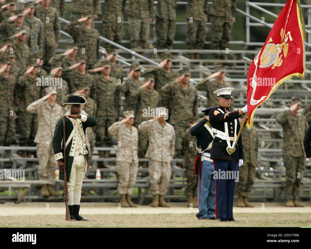 A U.S. Marine dressed in period uniform from 1775 salutes along with fellow Marines in the grand stands during a birthday pageant celebrating the the U.S. Marine Corps' 230th birthday at Camp Pendleton, California November 9, 2005. The Marine Corps tradition of observing three basic customs were honored to stands half full due to deployment of troops in Iraq. The Marines turn 230 November 10th. Stock Photo