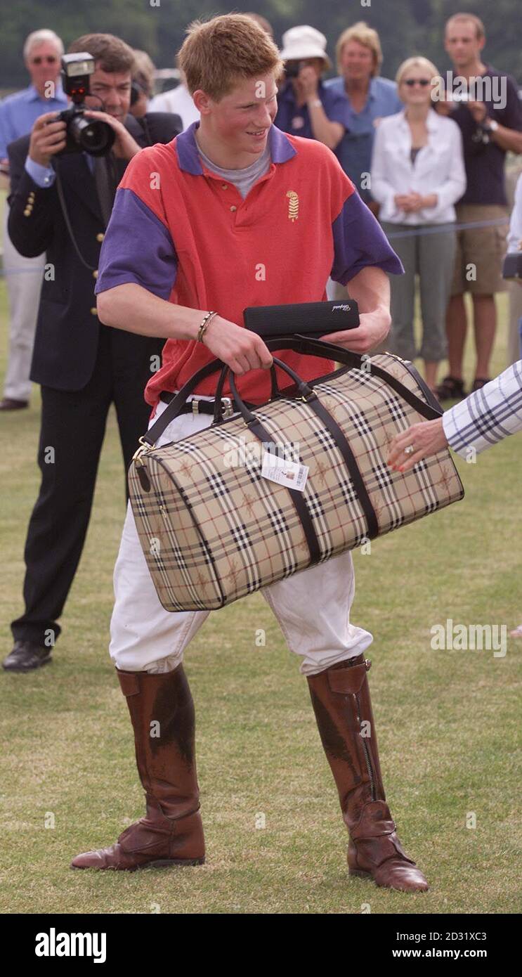 Prince Harry, youngest son of the Prince of Wales receives some Burberry luggage playing on the same losing side as his father, Highgrove, in a polo match at Cirencester Park Polo