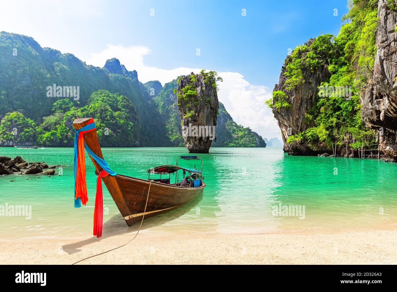Famous James Bond island near Phuket in Thailand. Travel photo of James Bond island with thai traditional wooden longtail boat and beautiful sand beac Stock Photo
