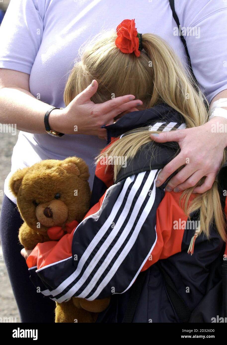 Comforting moment for one of the youngsters of Holy Cross Girl's primary School after she had been escorted along with other Catholic pupils and parents from the school through a Protestant estate in the Ardoyne area of Belfast. Stock Photo