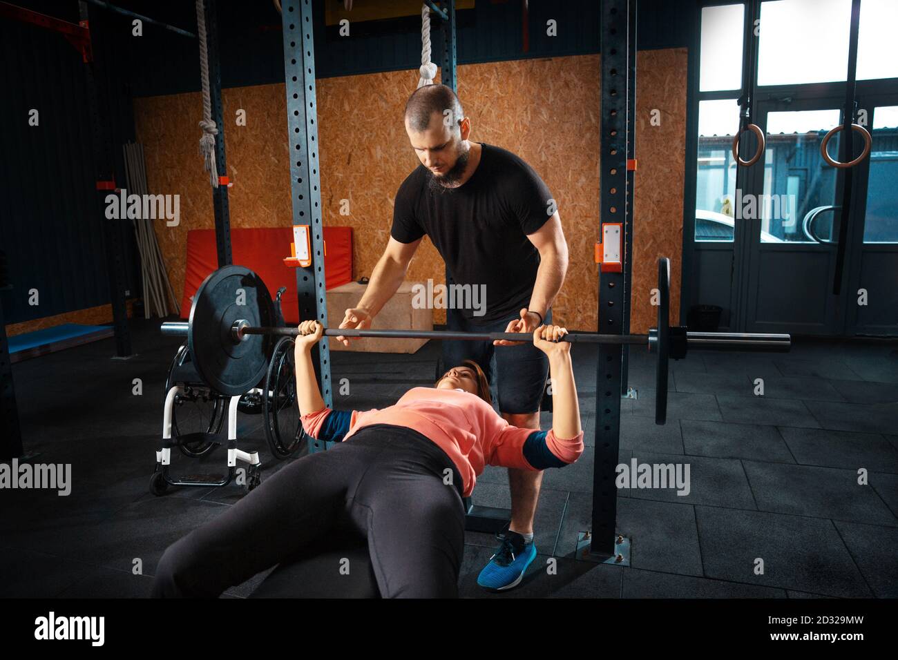 Barbell. Disabled woman training in the gym of rehabilitation center, practicing. Active woman with handicap. Concept of healthy lifestyle, motivation, concentration, inclusion and diversity. Stock Photo